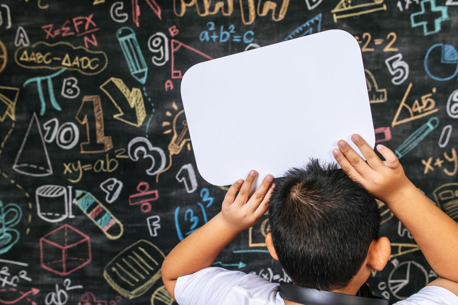 Child acting with speech bubble in the classroom photo