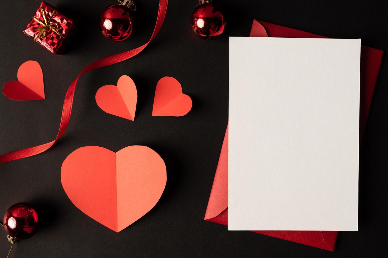 White paper and red heart paper pasted on a black background. photo