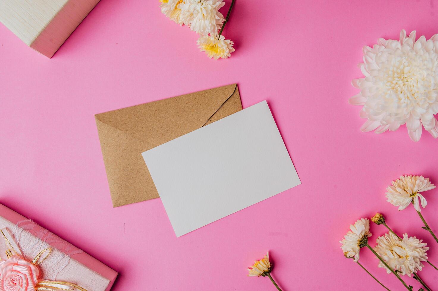 sobre marrón, caja de regalo rosa con tarjeta en blanco y flor foto