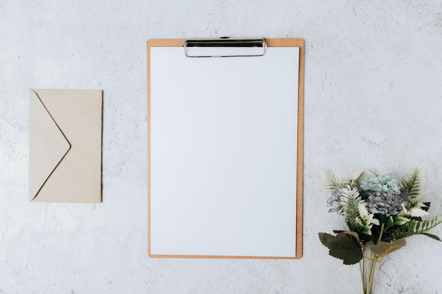 papel de nota, membrete y flores colocadas sobre un fondo blanco. foto