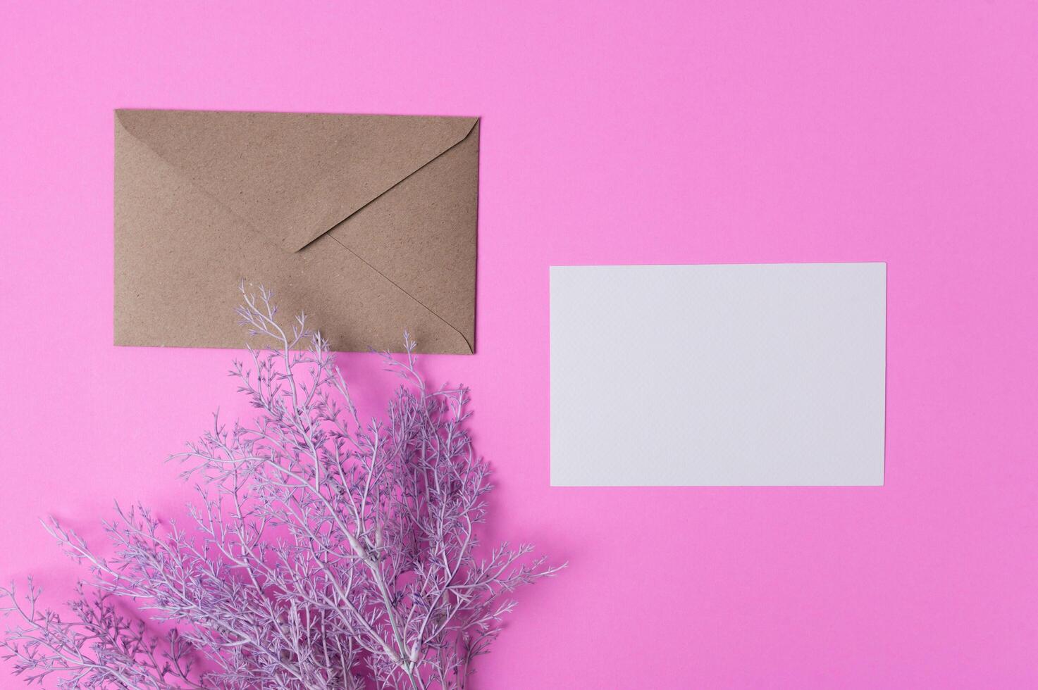 Blank paper with flowers placed on a pink background photo