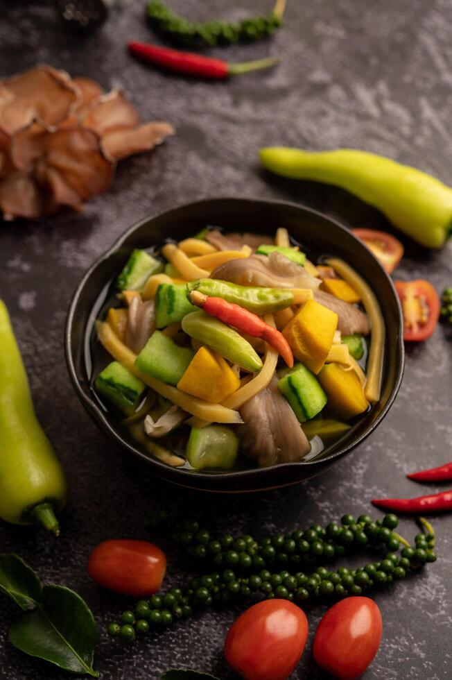 Kaeng Liang in a bowl with spices on a black cement floor. photo