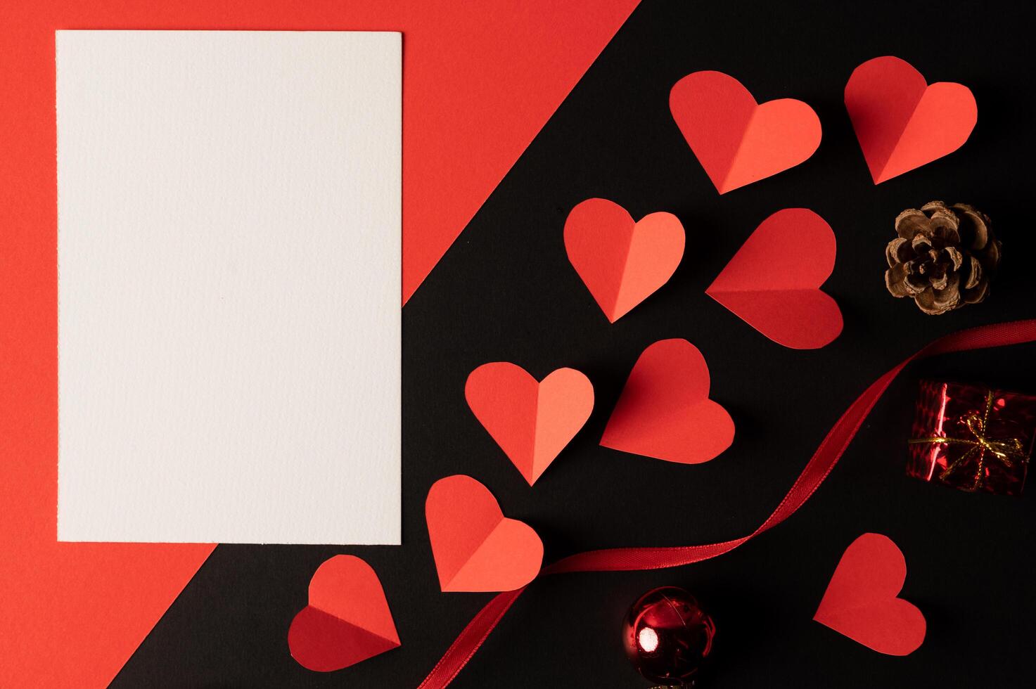 White paper and red heart paper pasted on a black background. photo