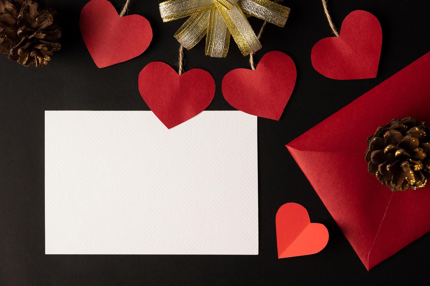 White paper and red heart paper pasted on a black background. photo