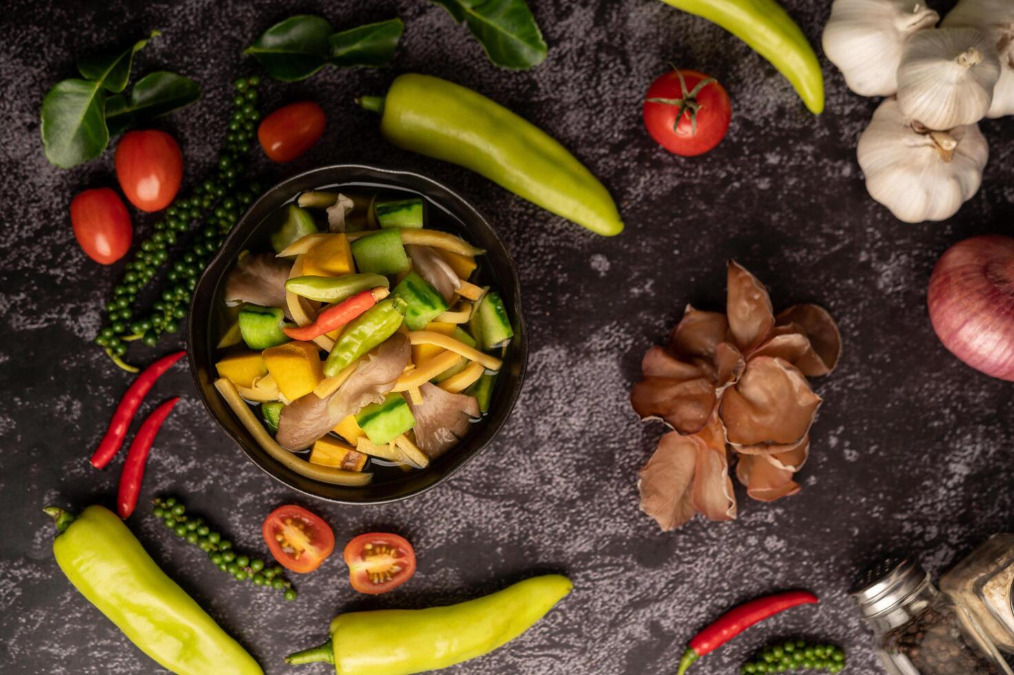 Kaeng Liang in a bowl with spices on a black cement floor. photo