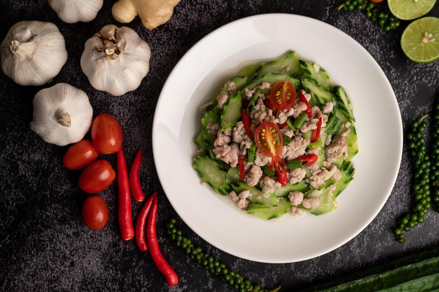 Calabacín salteado con carne de cerdo picada en un plato blanco foto