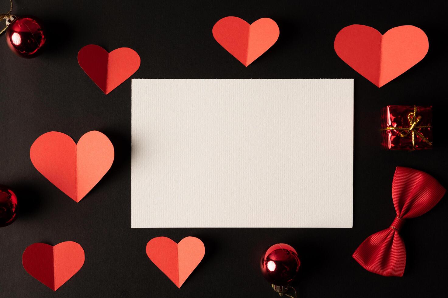 White paper and red heart paper pasted on a black background. photo