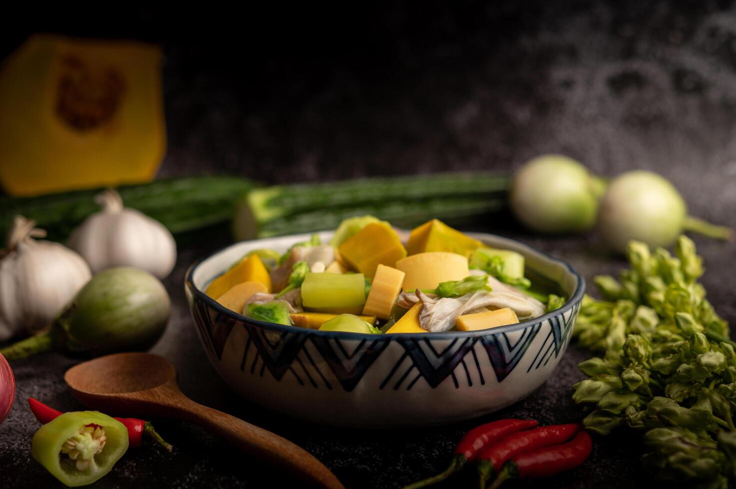 Kaeng Liang in a bowl with spices on a black cement floor. photo