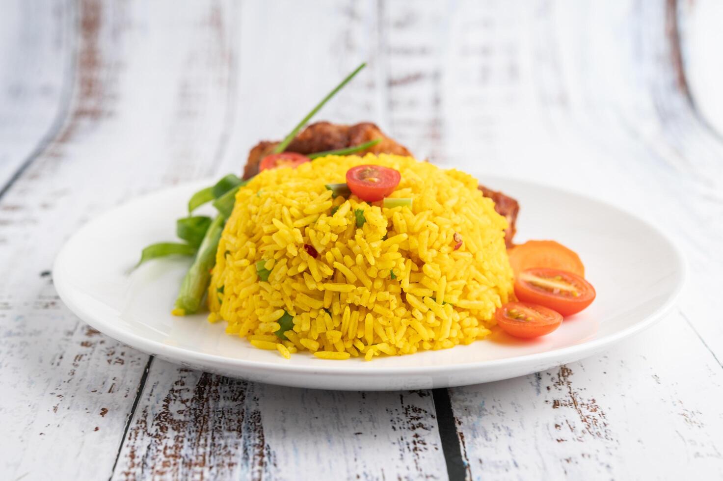 Biryani de pollo en un plato sobre un piso de madera blanca foto