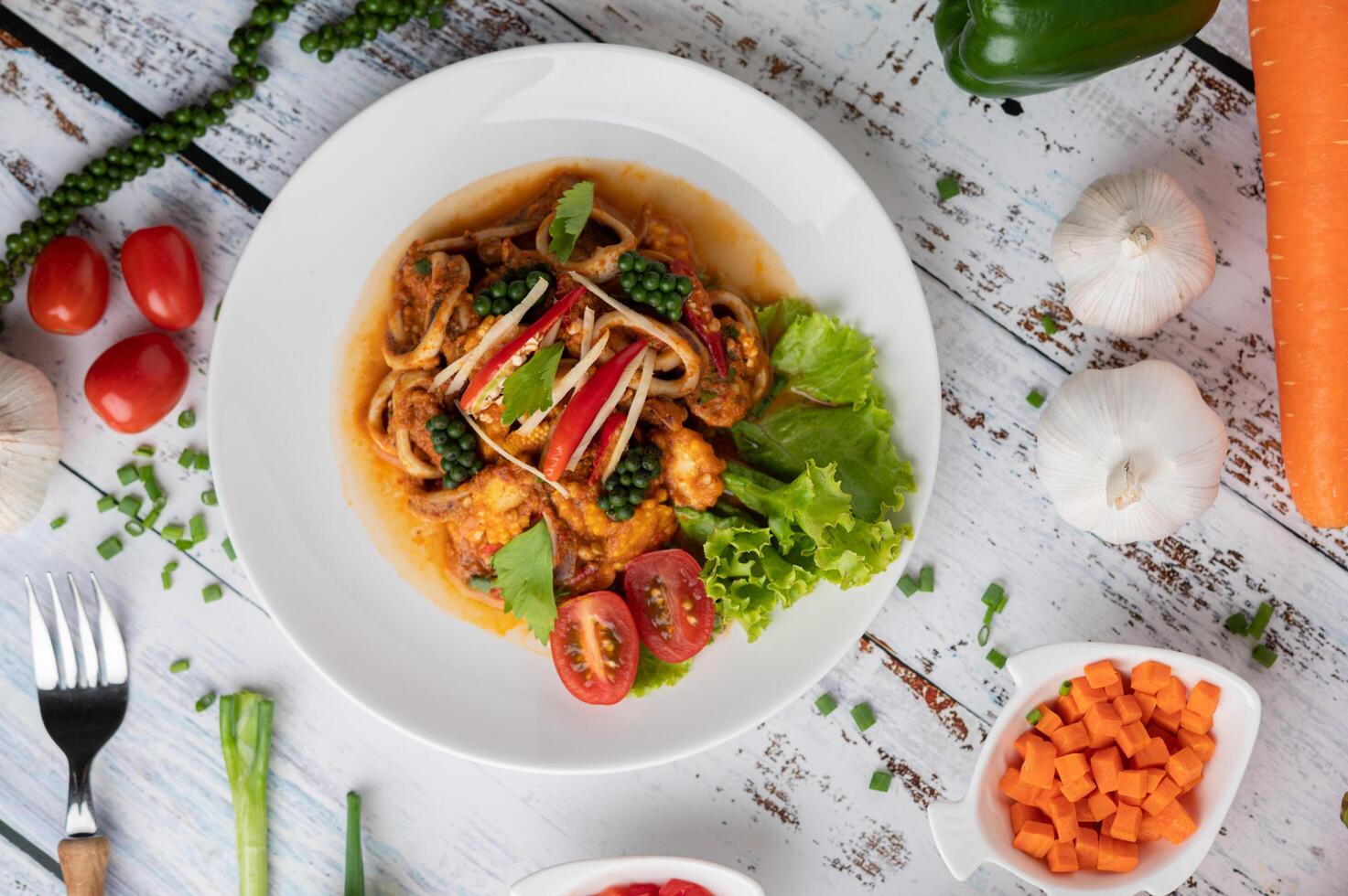 Stir-fried squid with curry paste in white plate. photo