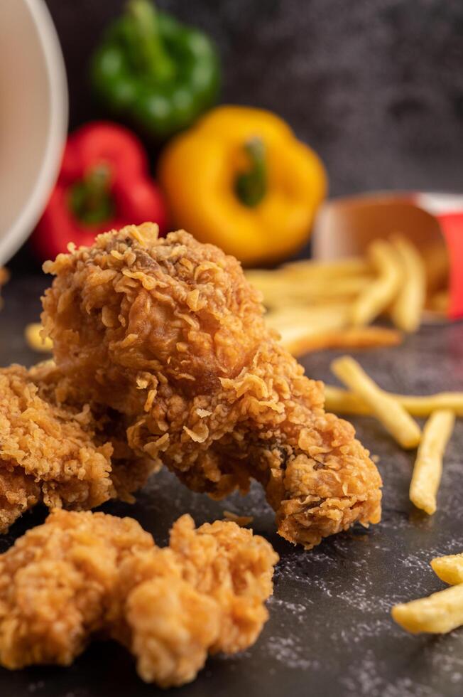 Fried Chicken and French Fries on Black Cement Floor. photo