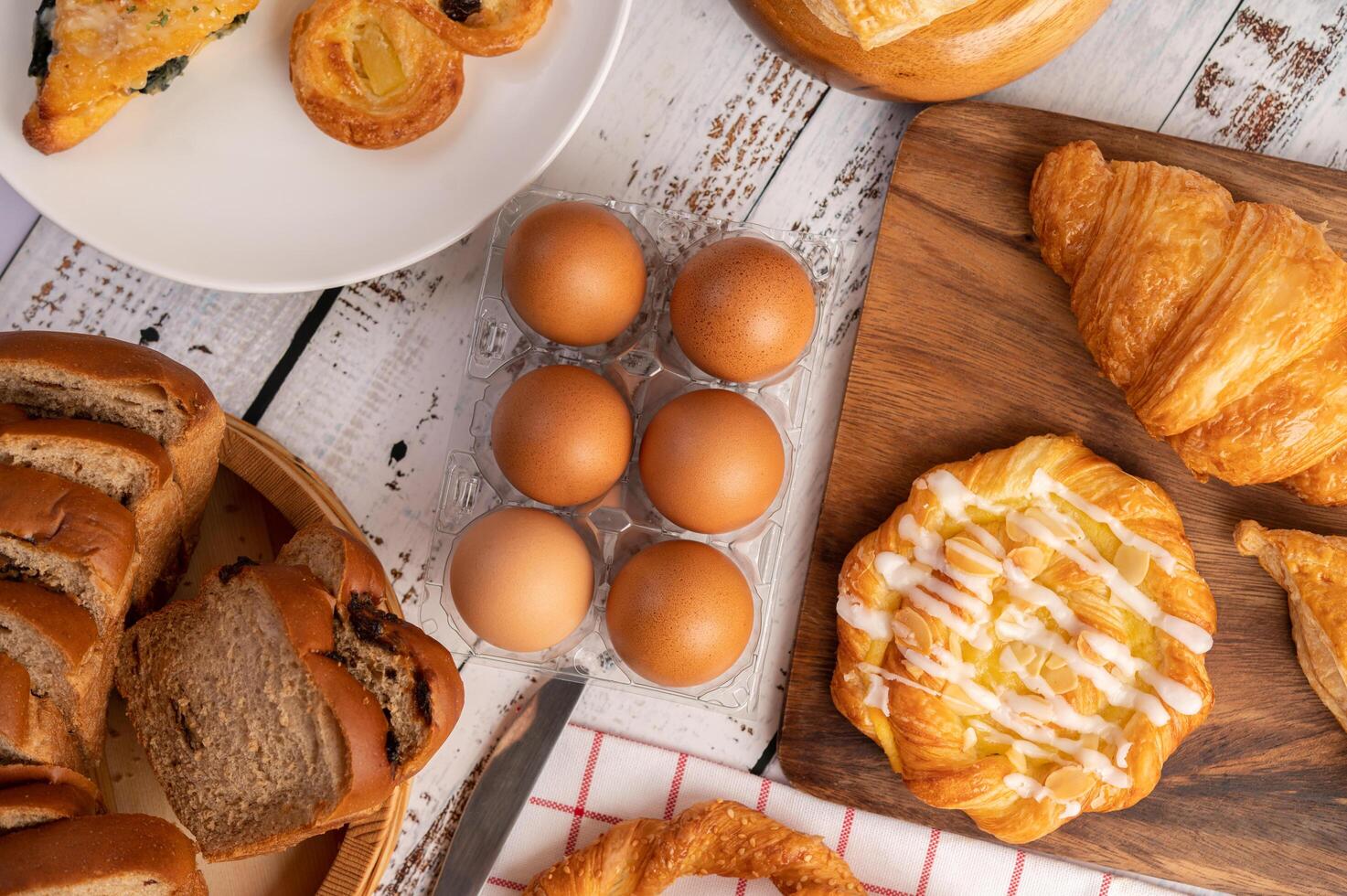 Various breads and eggs on red white cloth. Selective focus. photo