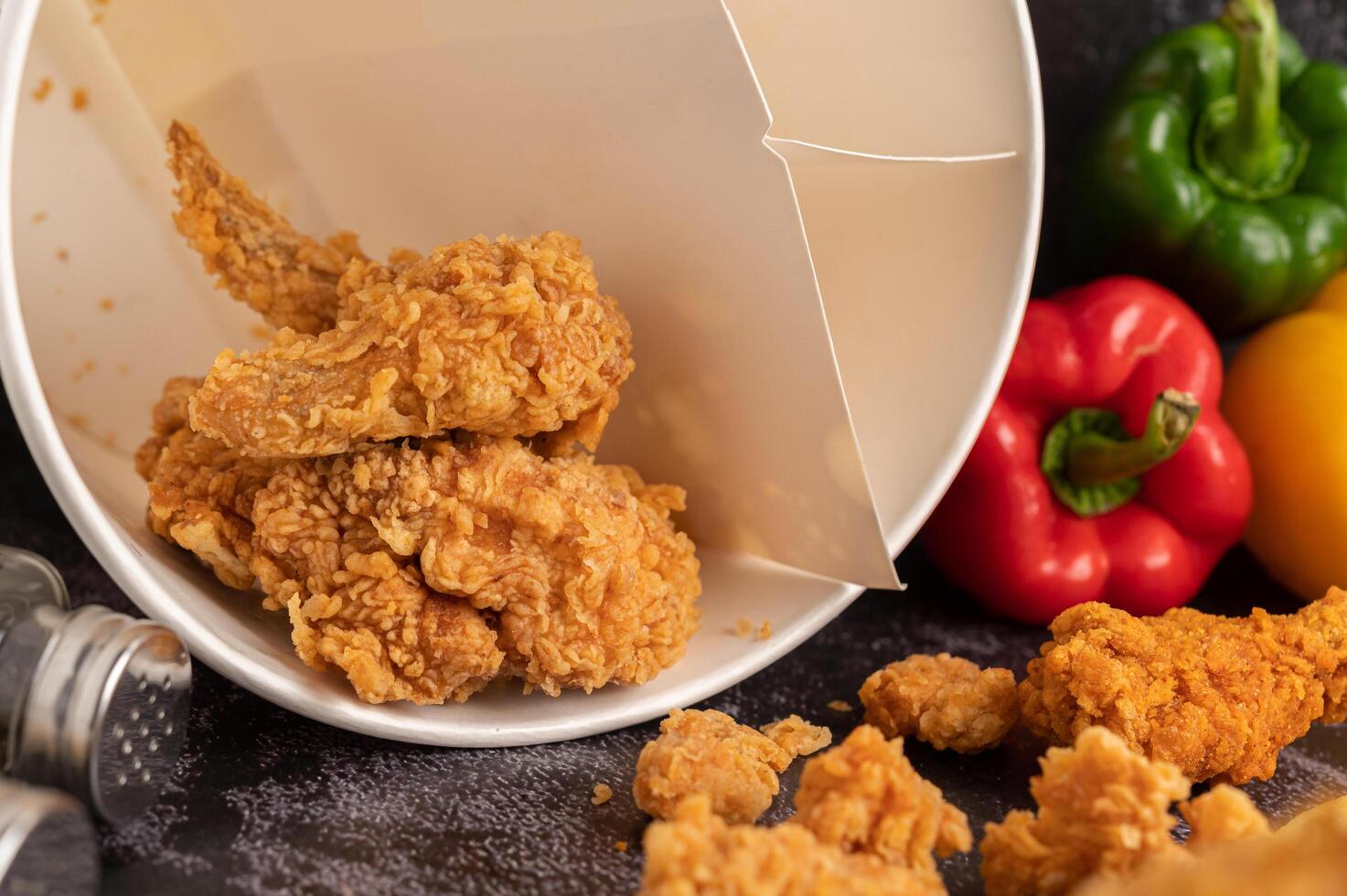Fried Chicken and French Fries on Black Cement Floor. photo