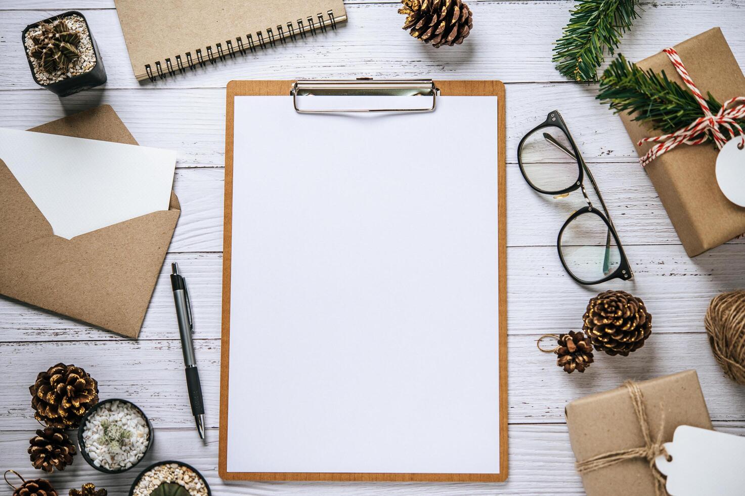 The clipboard is placed on a white wooden table with glasses photo