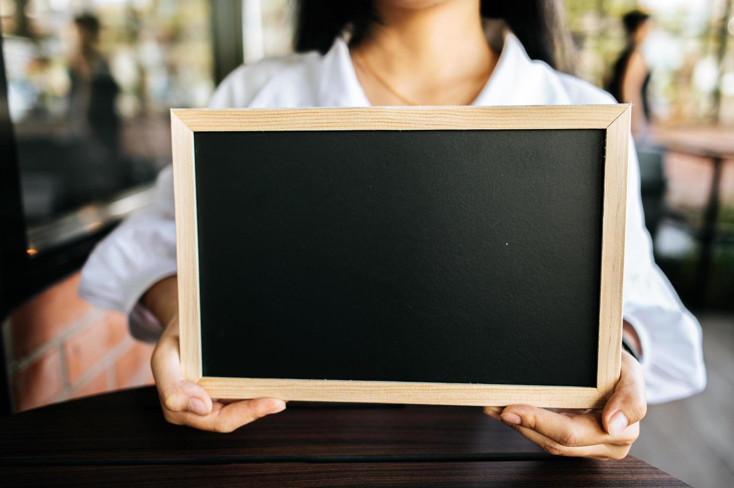 woman holding black board in cafe photo