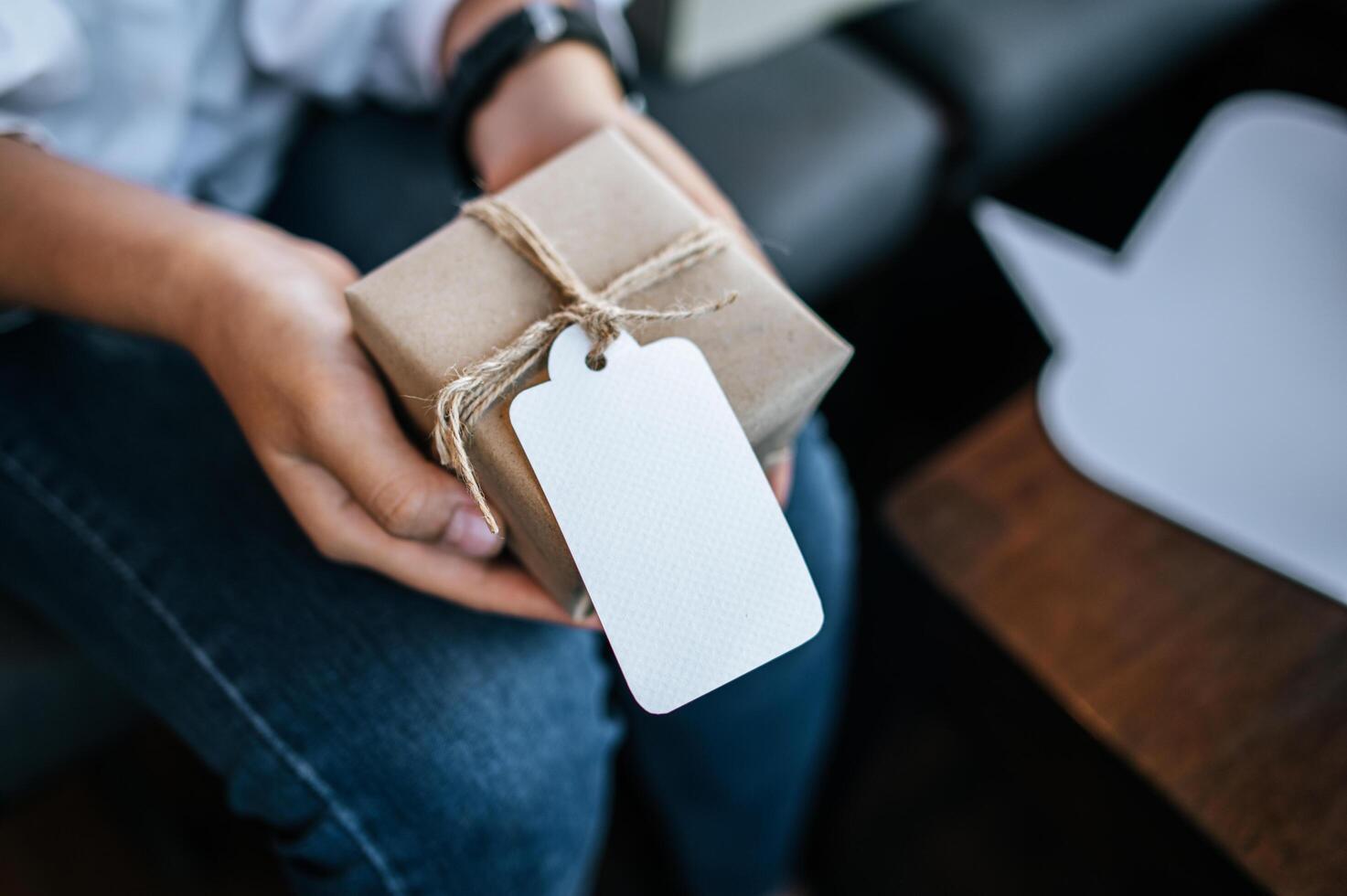 Mujer sosteniendo una caja de paquetería en el café foto