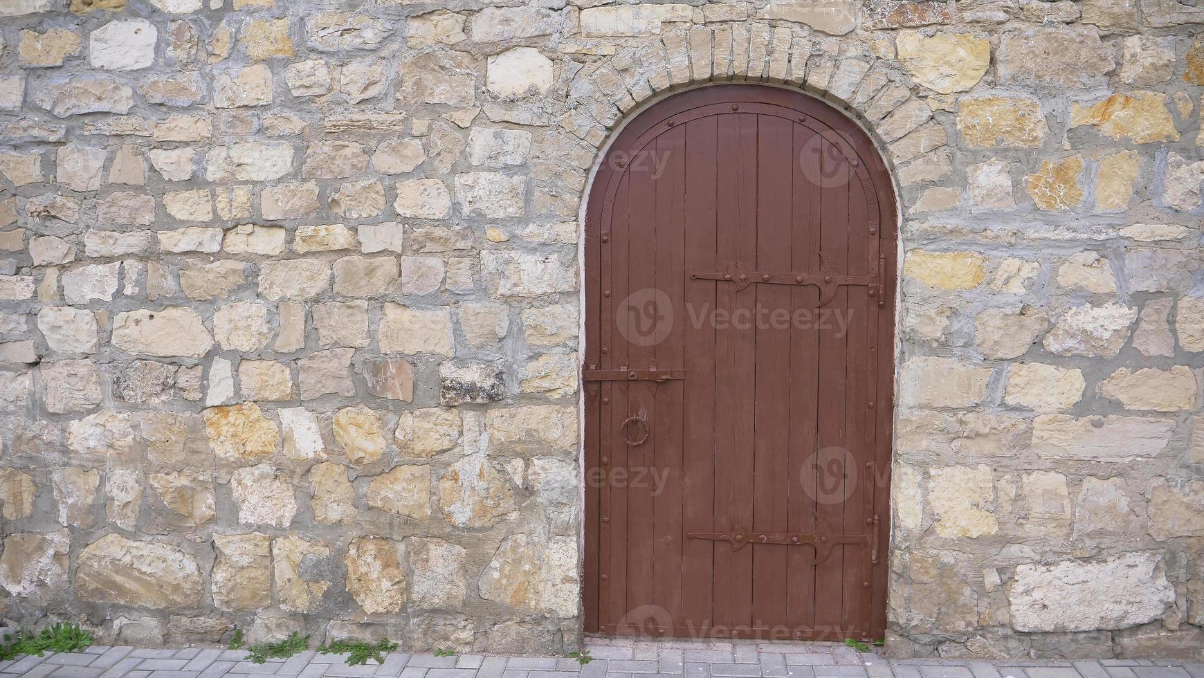 Retro vintage stone brick wall and old wooden door background photo