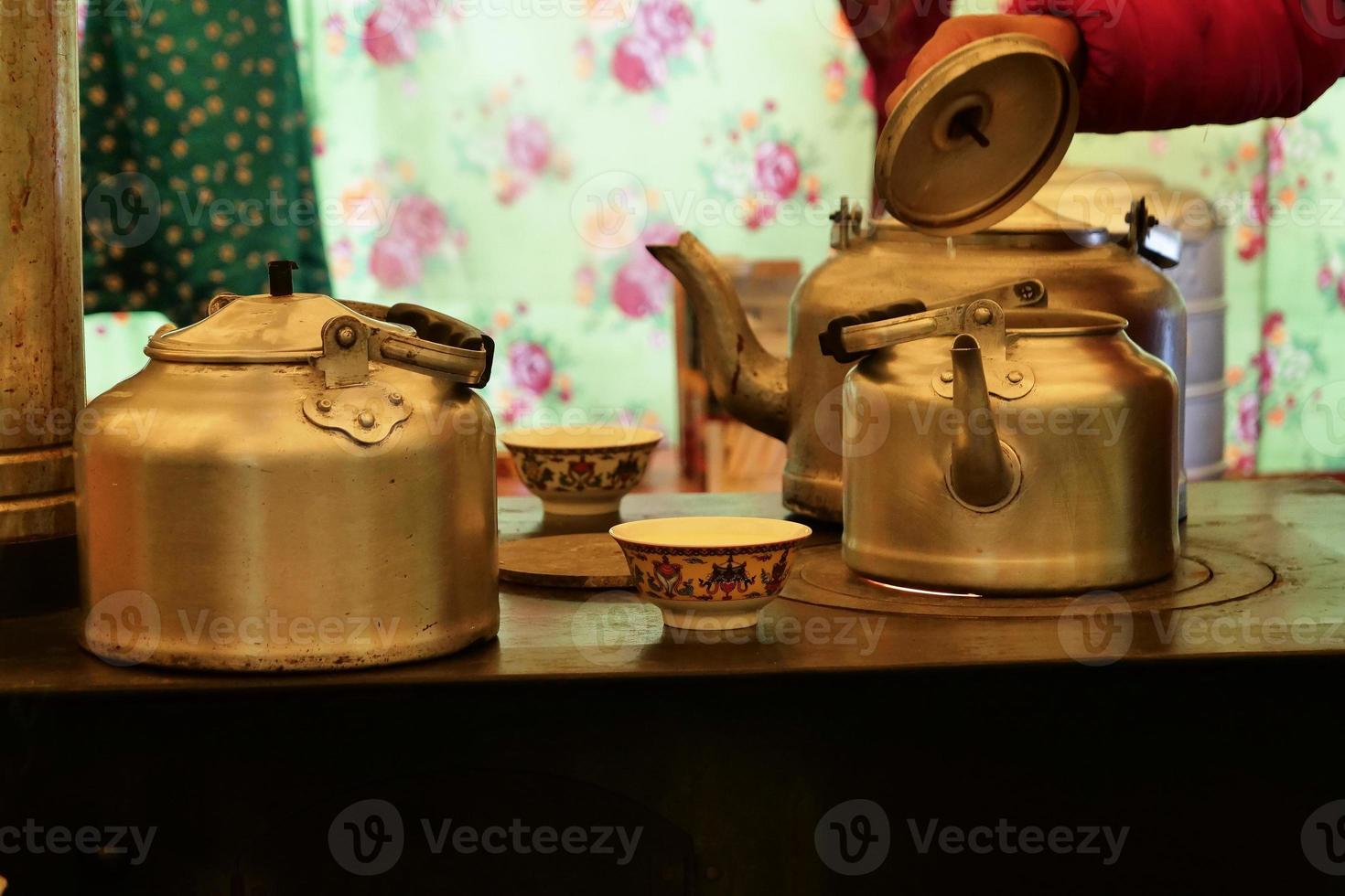 Preparing tea with metal tea pot inside a yurt in Laji Shan photo