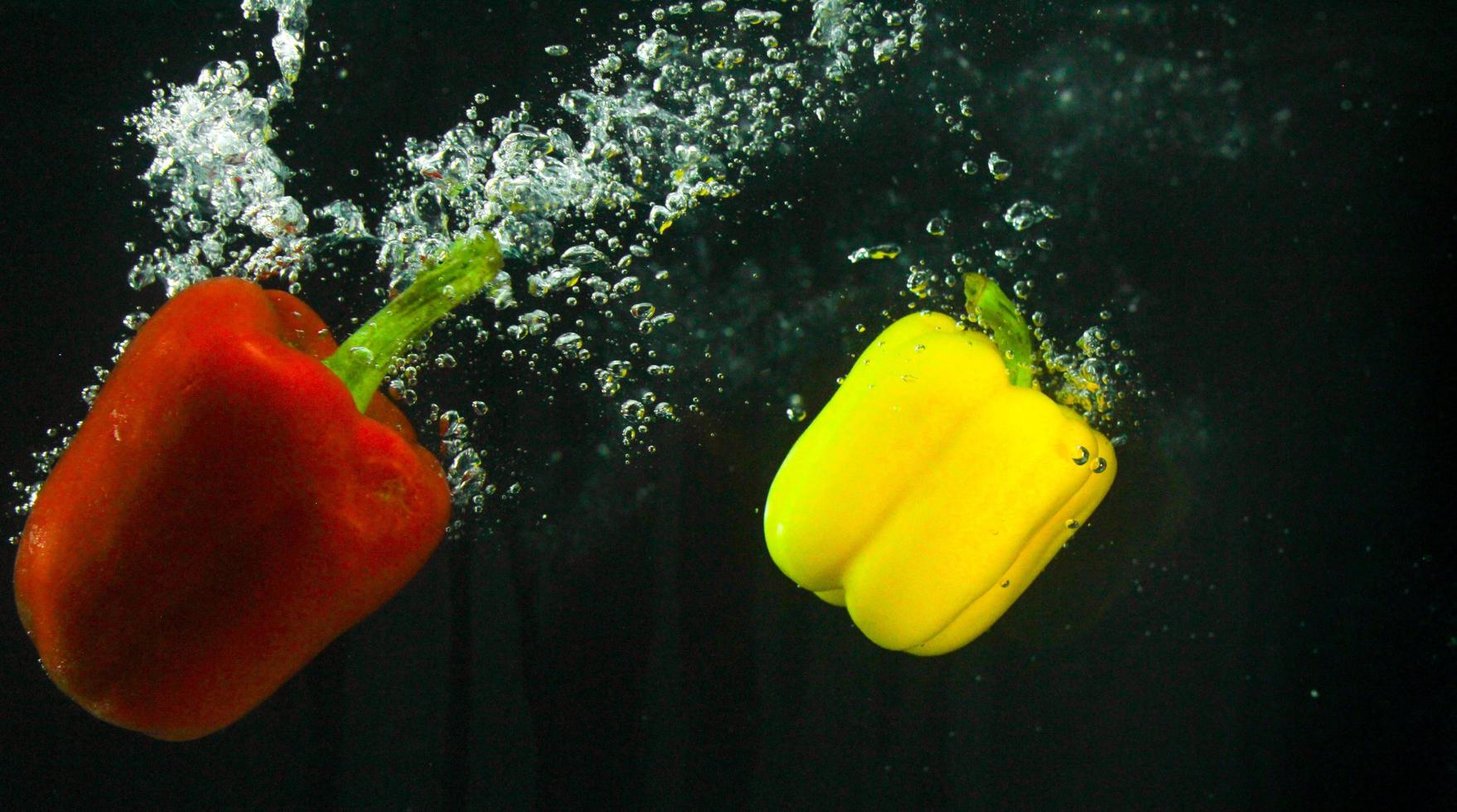 Photo of fresh vegetables falling in the water with bubble