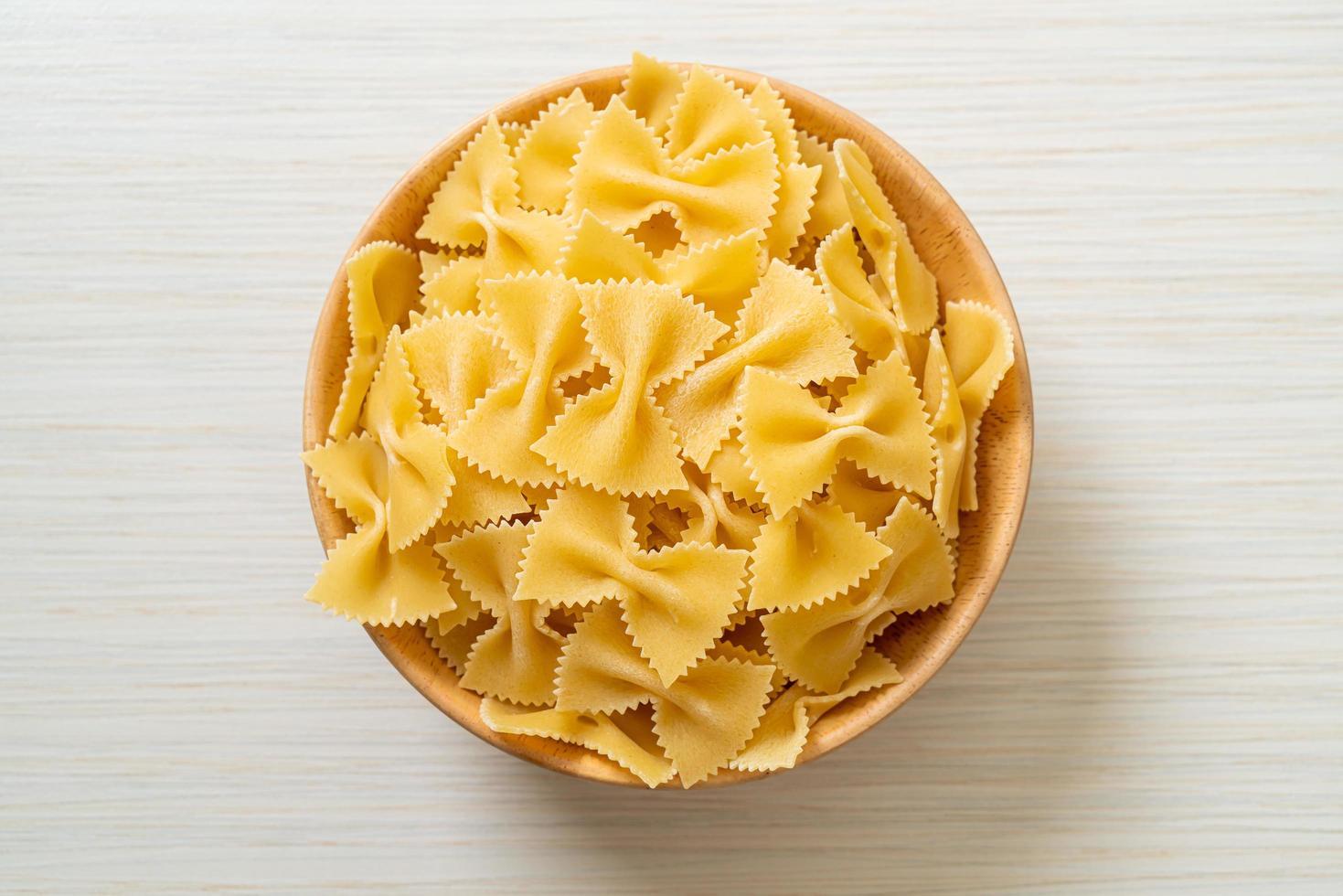 Dry uncooked farfalle pasta in bowl photo