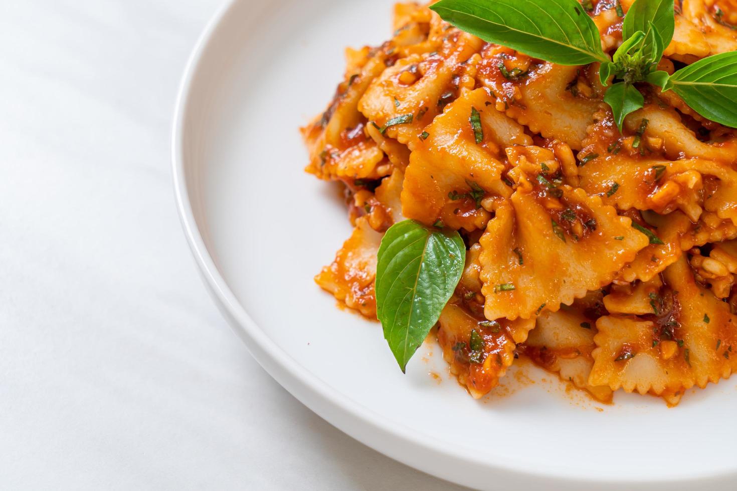 pasta farfalle con albahaca y ajo en salsa de tomate foto