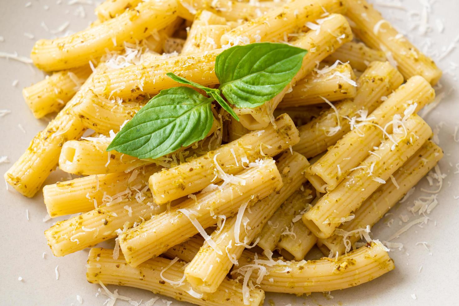 Pesto rigatoni pasta with parmesan cheese photo