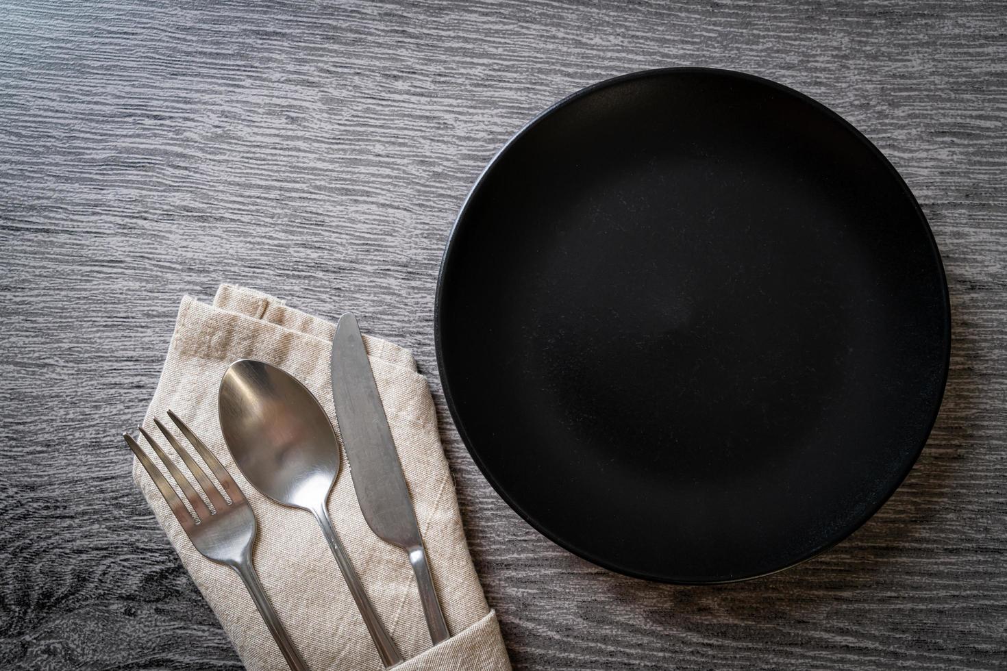 Empty plate or dish with knife, fork and spoon photo