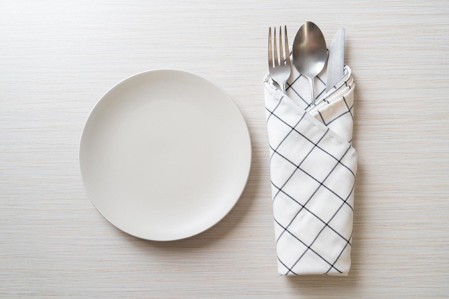 Empty plate or dish with knife, fork and spoon photo