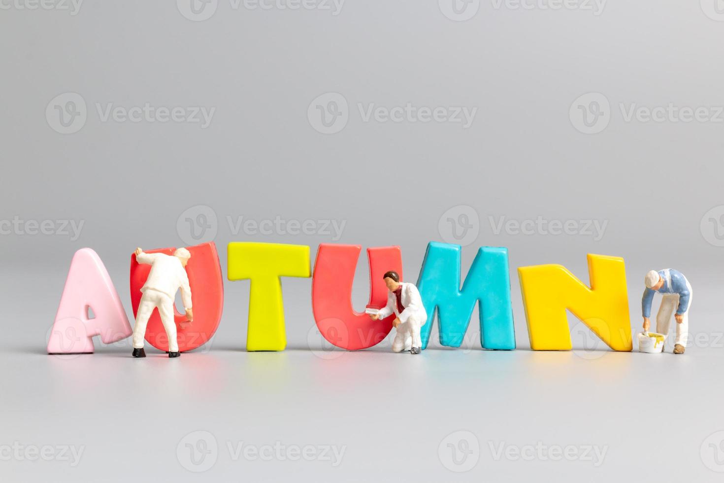 Miniature people worker team painting of Autumn with place for text photo
