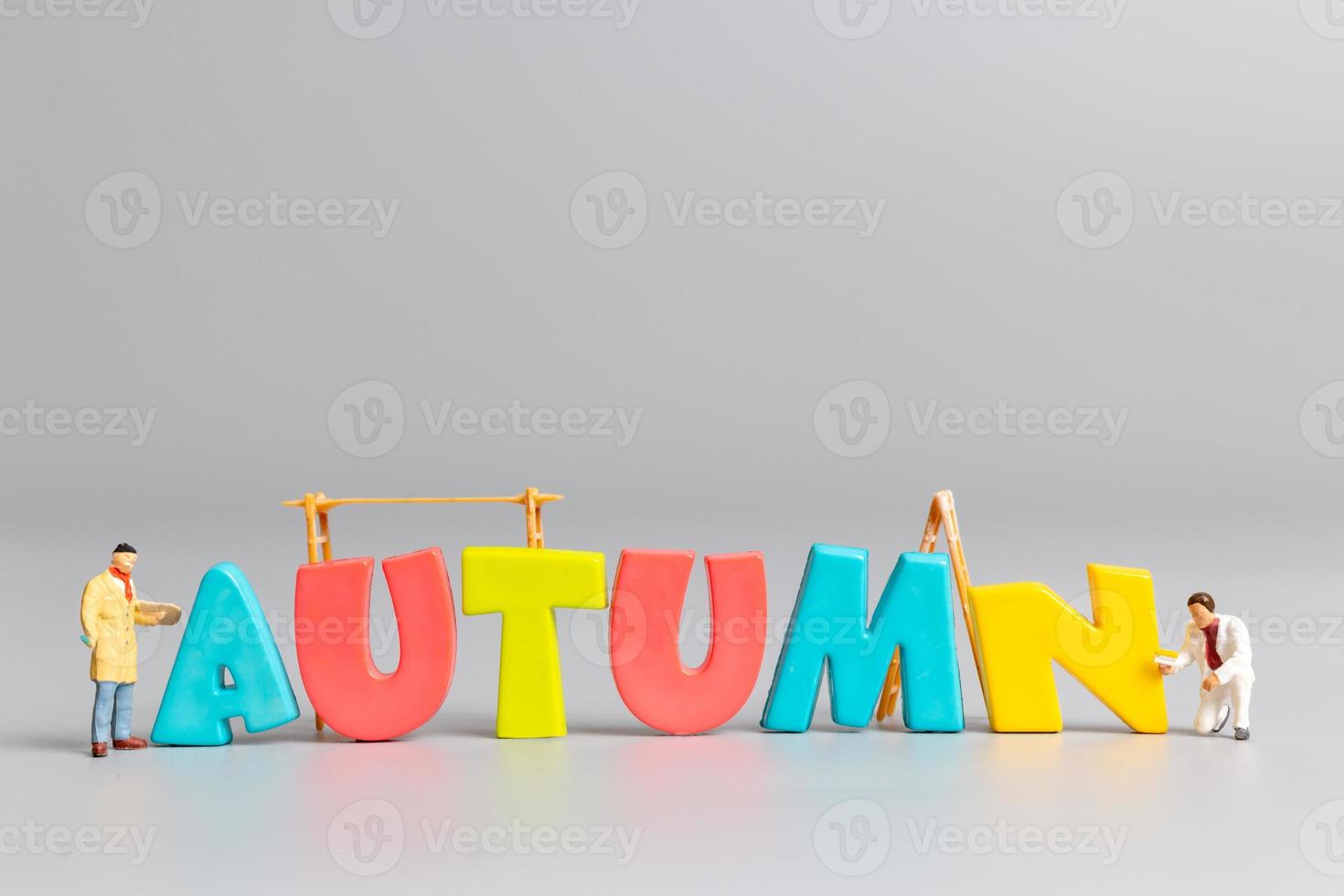 Miniature people worker team painting of Autumn with place for text photo