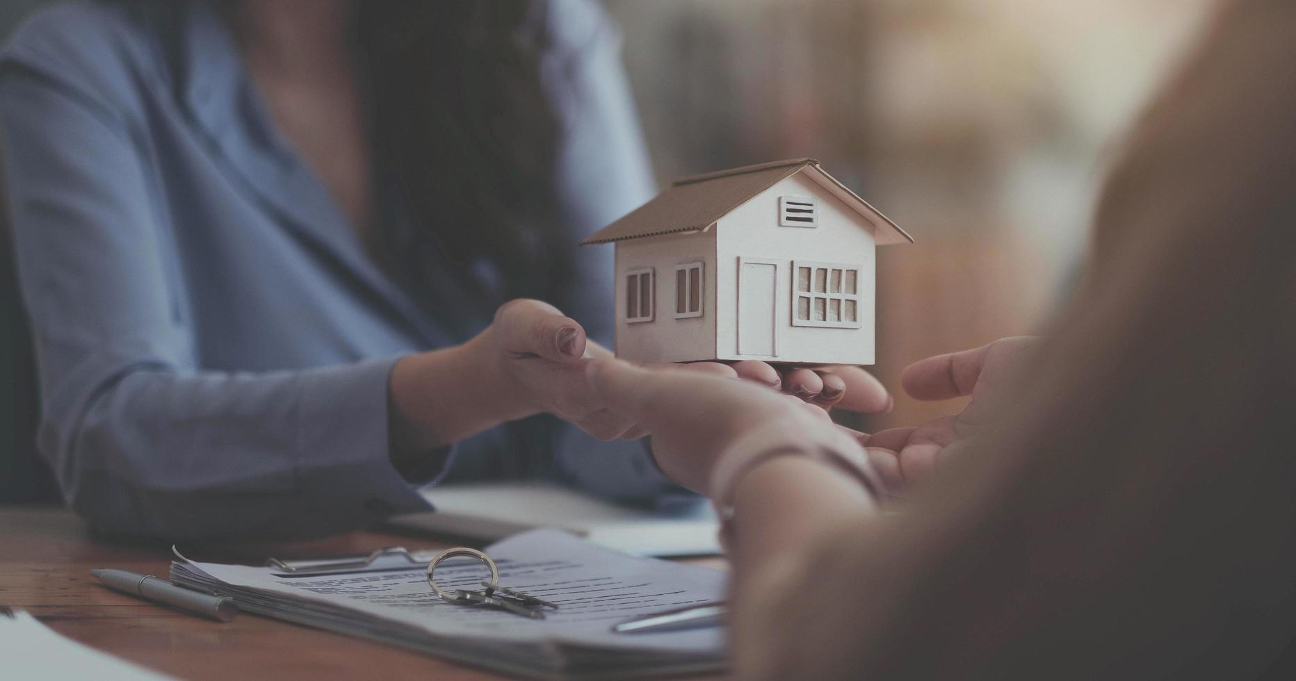 Estate agent giving house keys to customer after contract signature photo