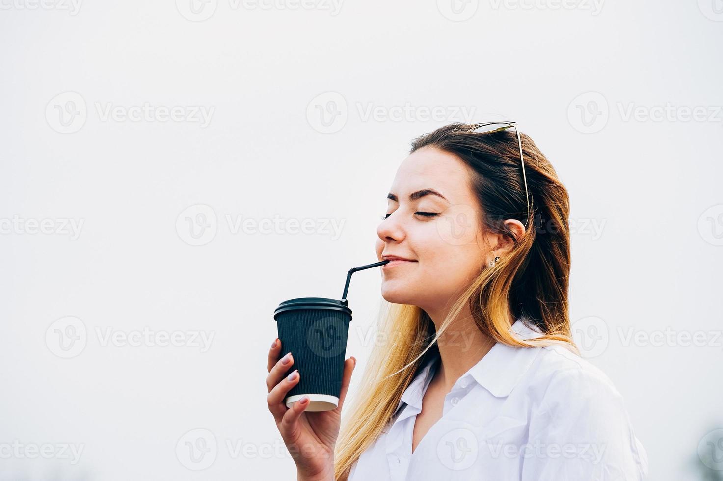 Chica guapa tomando café, sonriendo, ojos cerrados, espacio de copia foto