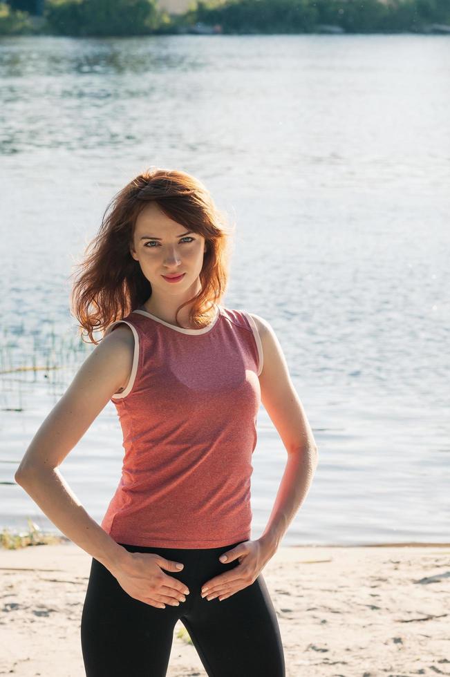 fit pretty girl practice exercise outdoors on beach photo