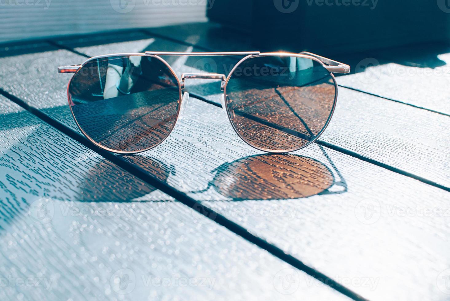 gafas de sol marrones de moda, tonos azules en la mesa foto