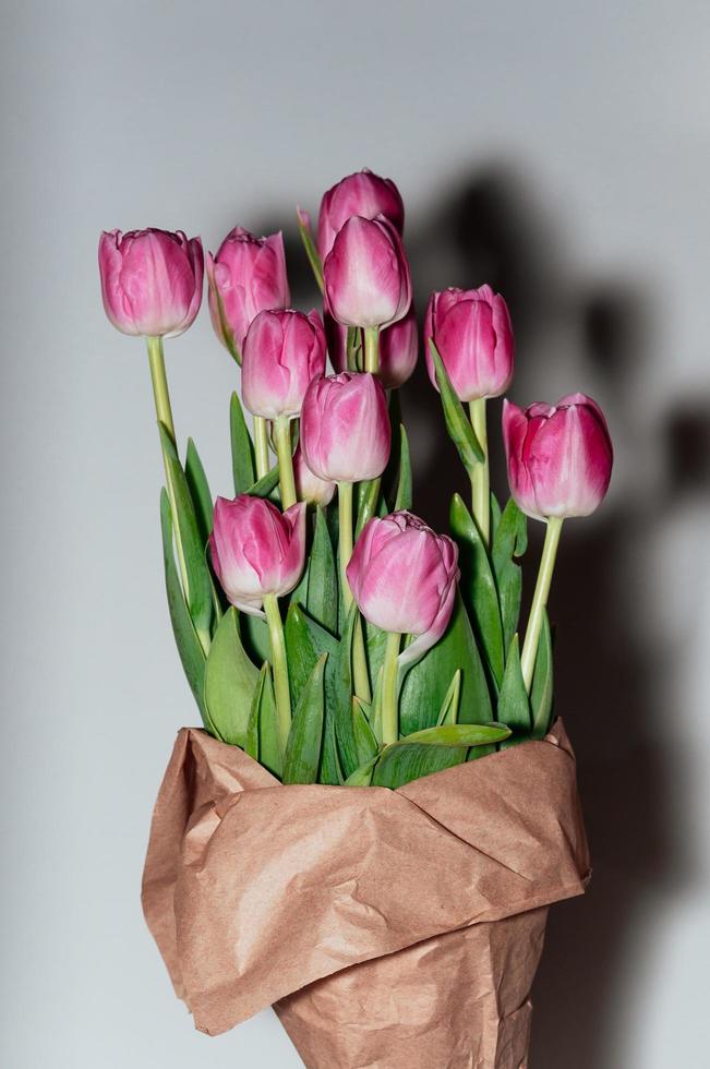 pink big tulip flowers in craft package photo