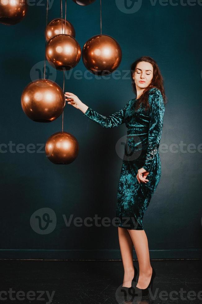 hermosa mujer joven en vestido de terciopelo azul verde, posando foto