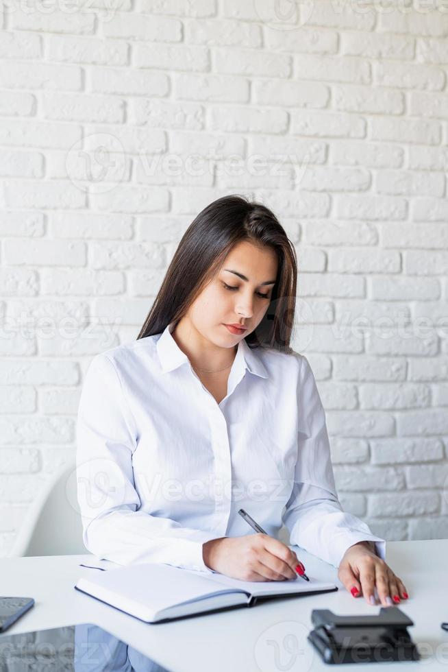 Young female lawyer working making notes in the notebook photo