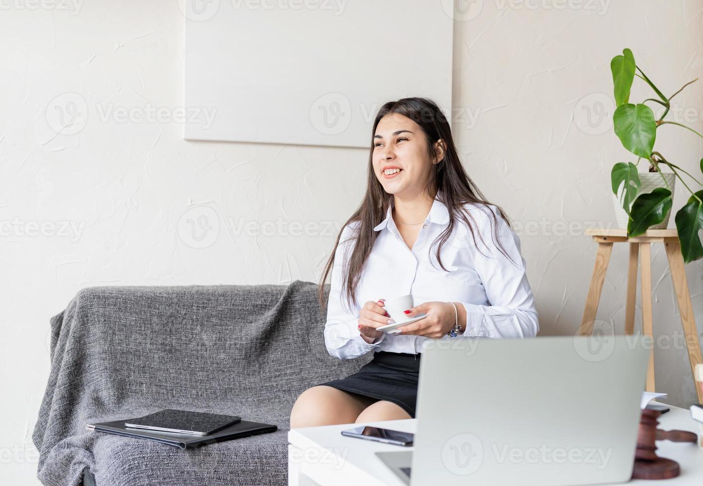 lawyer working at the laptop sitting on the couch drinking coffee photo