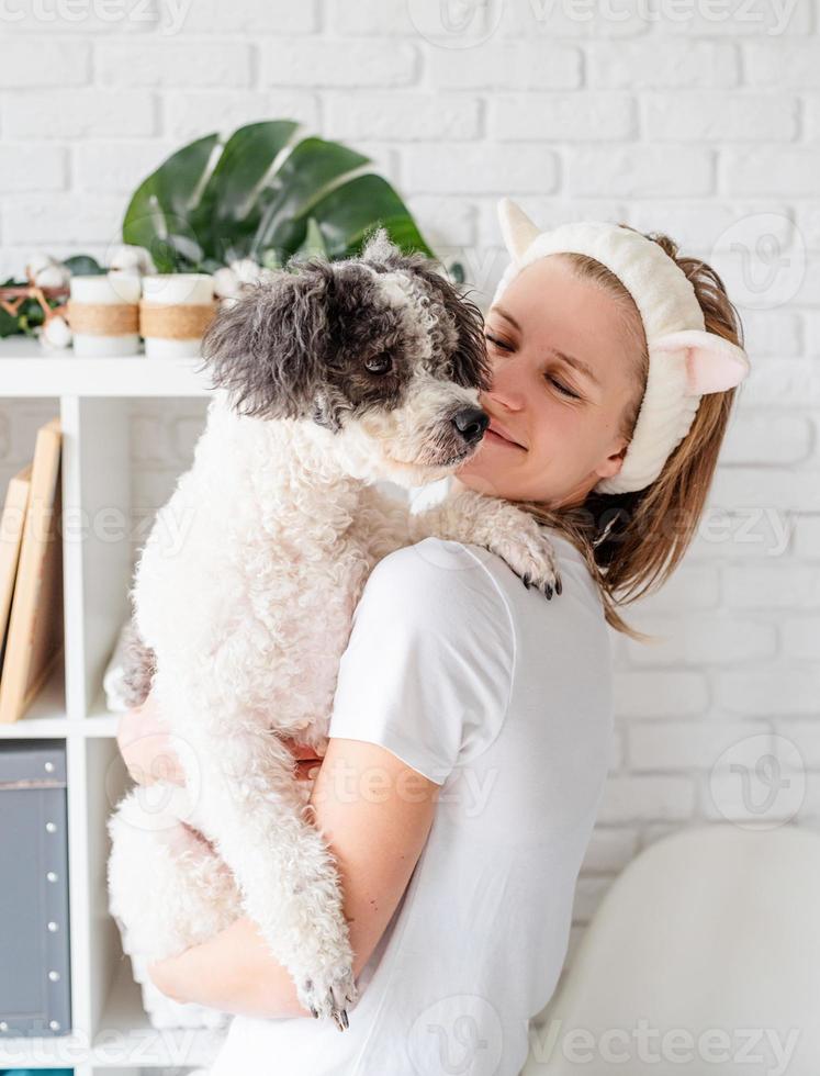 woman wearing bathrobes doing spa procedures with her dog photo