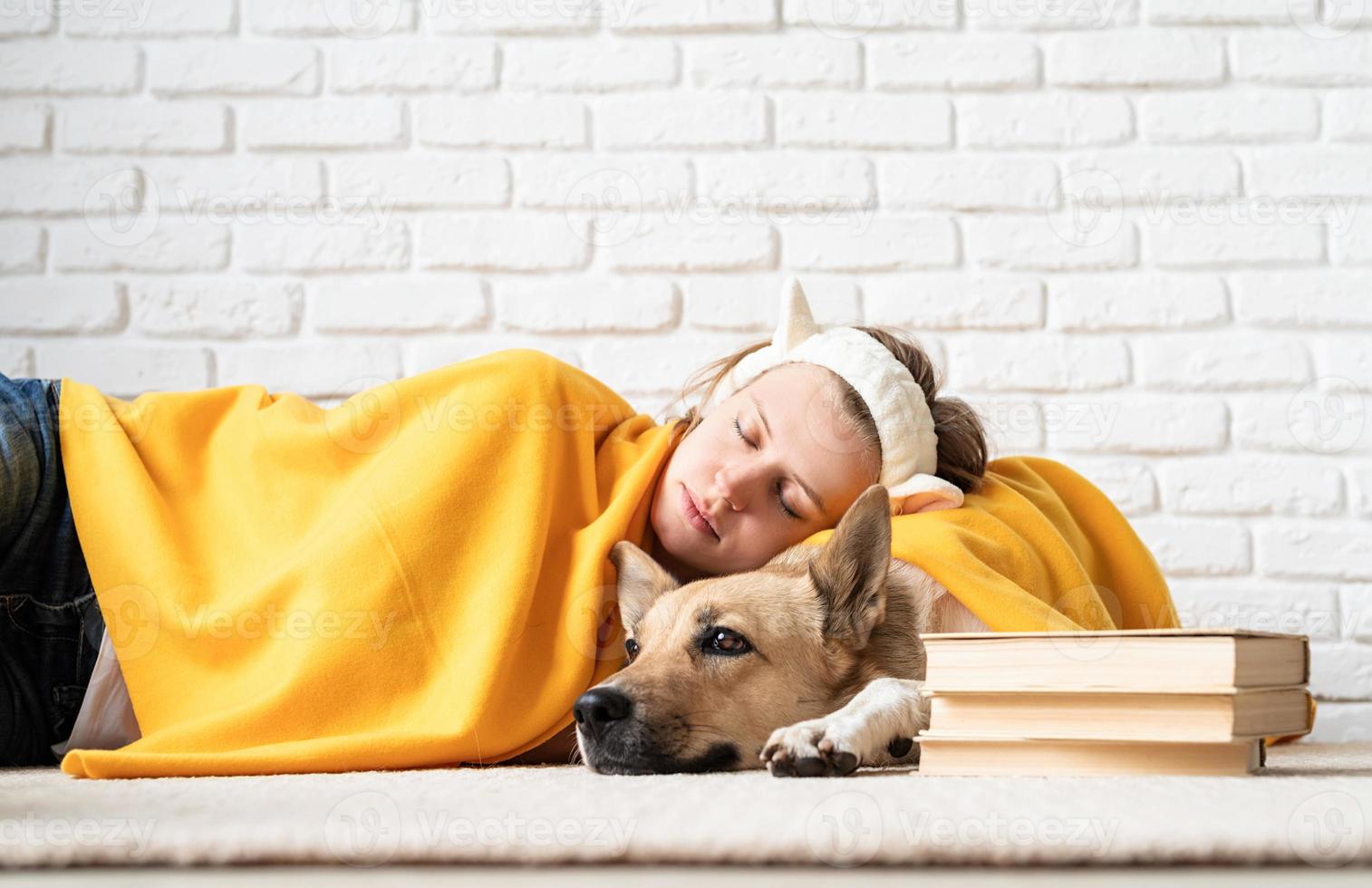 Funny young woman in yellow plaid sleeping with her dog photo