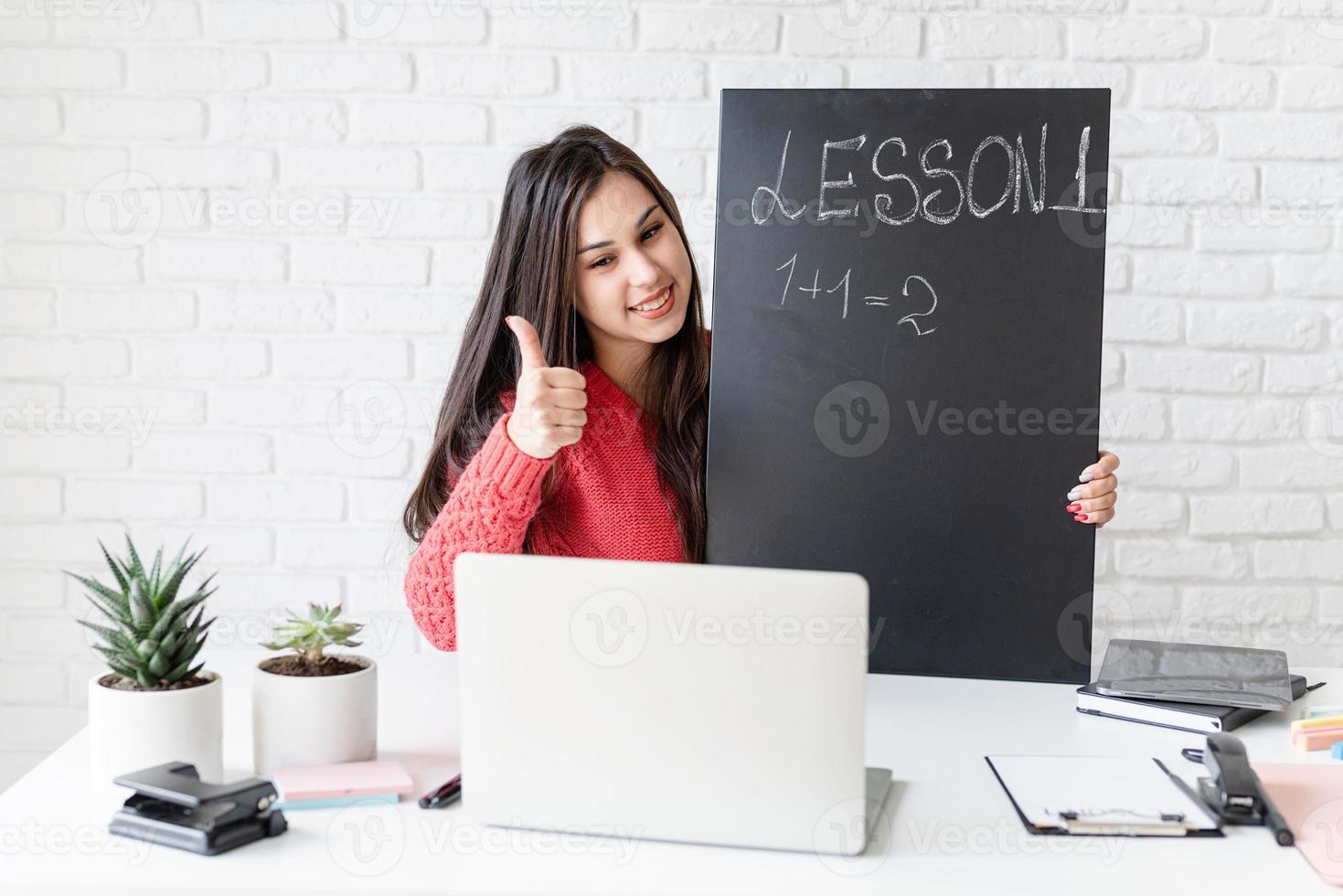 Young latin woman in black headphones teaching english online photo