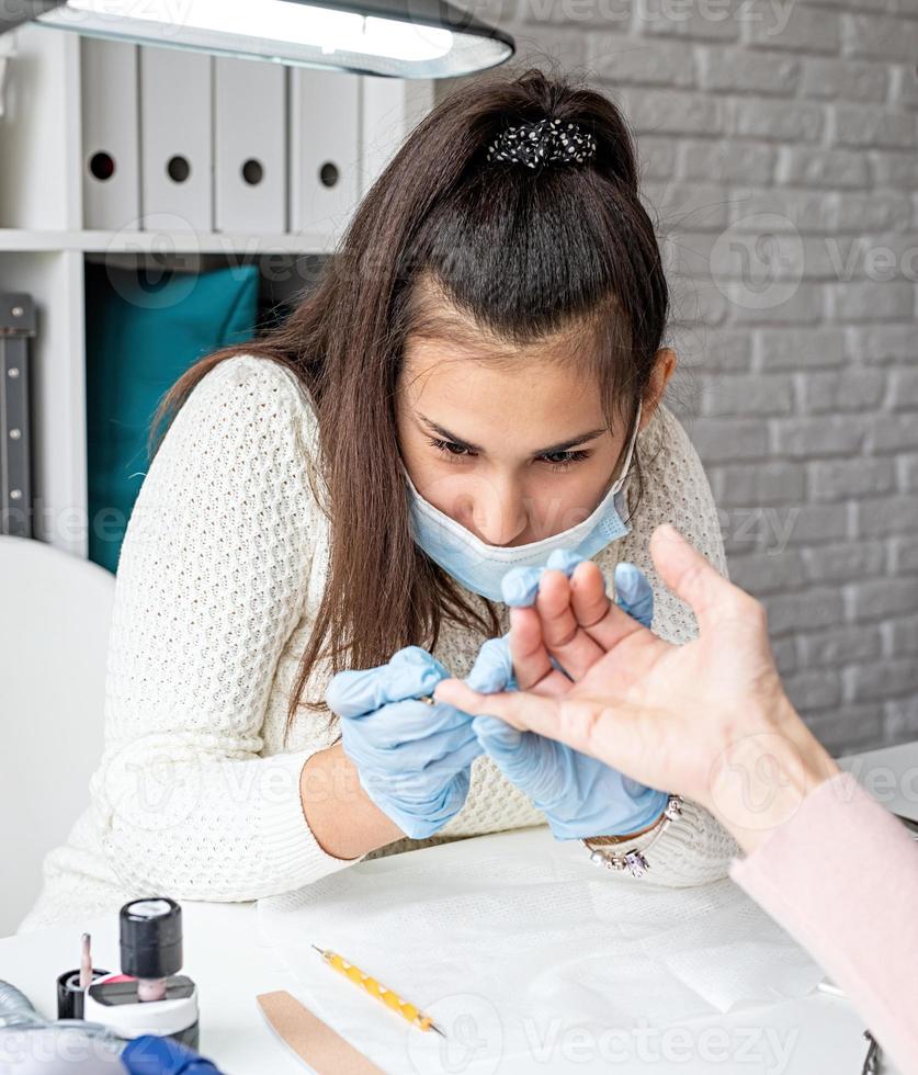 Manicure master in mask and gloves photo