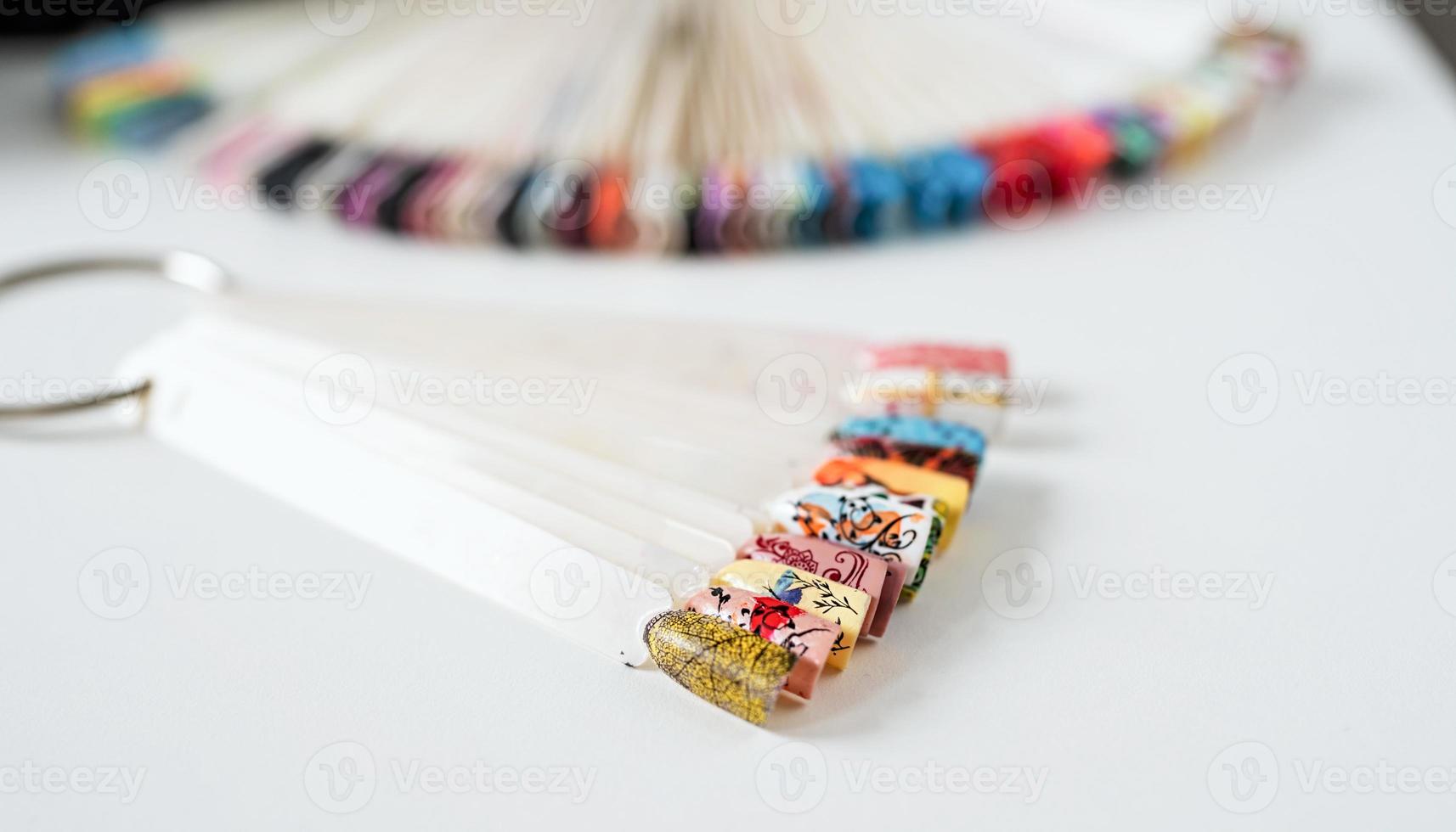 Colorful plastic nail tips on the table in manicure salon photo