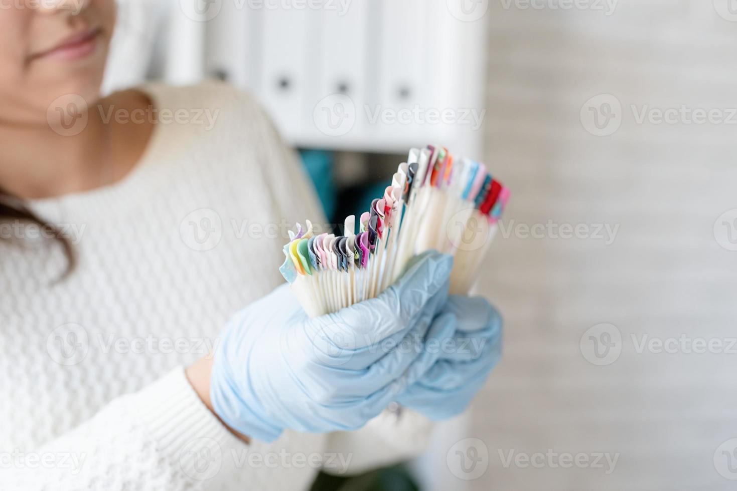 Maestro de manicura en guantes trabajando en salón de uñas foto