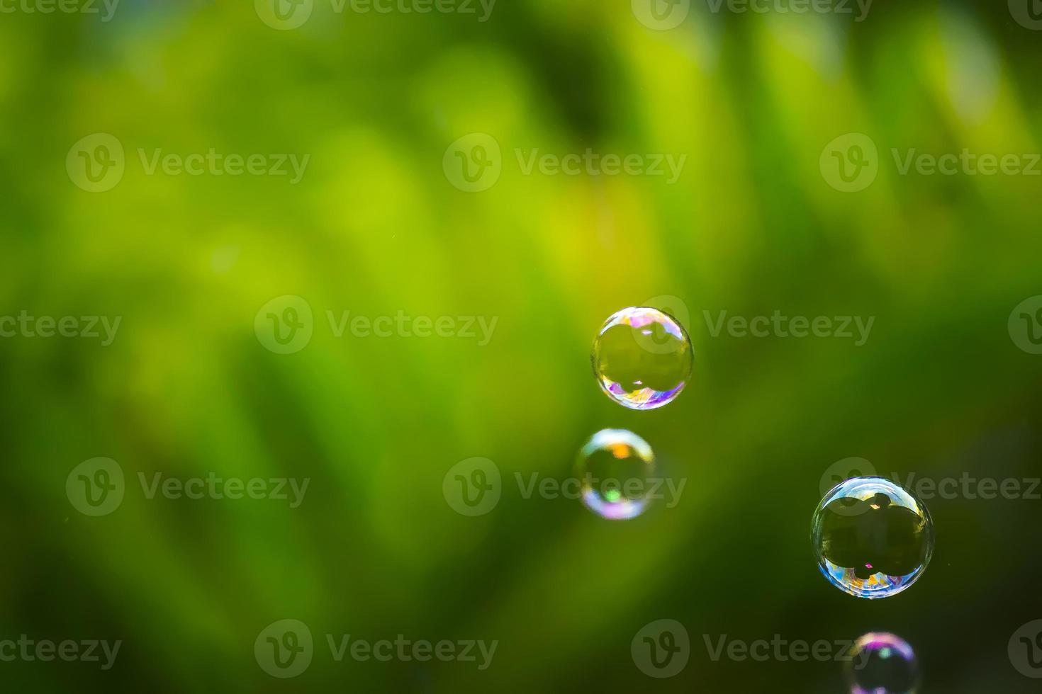 Water bubbles floating and falling on green leaves photo