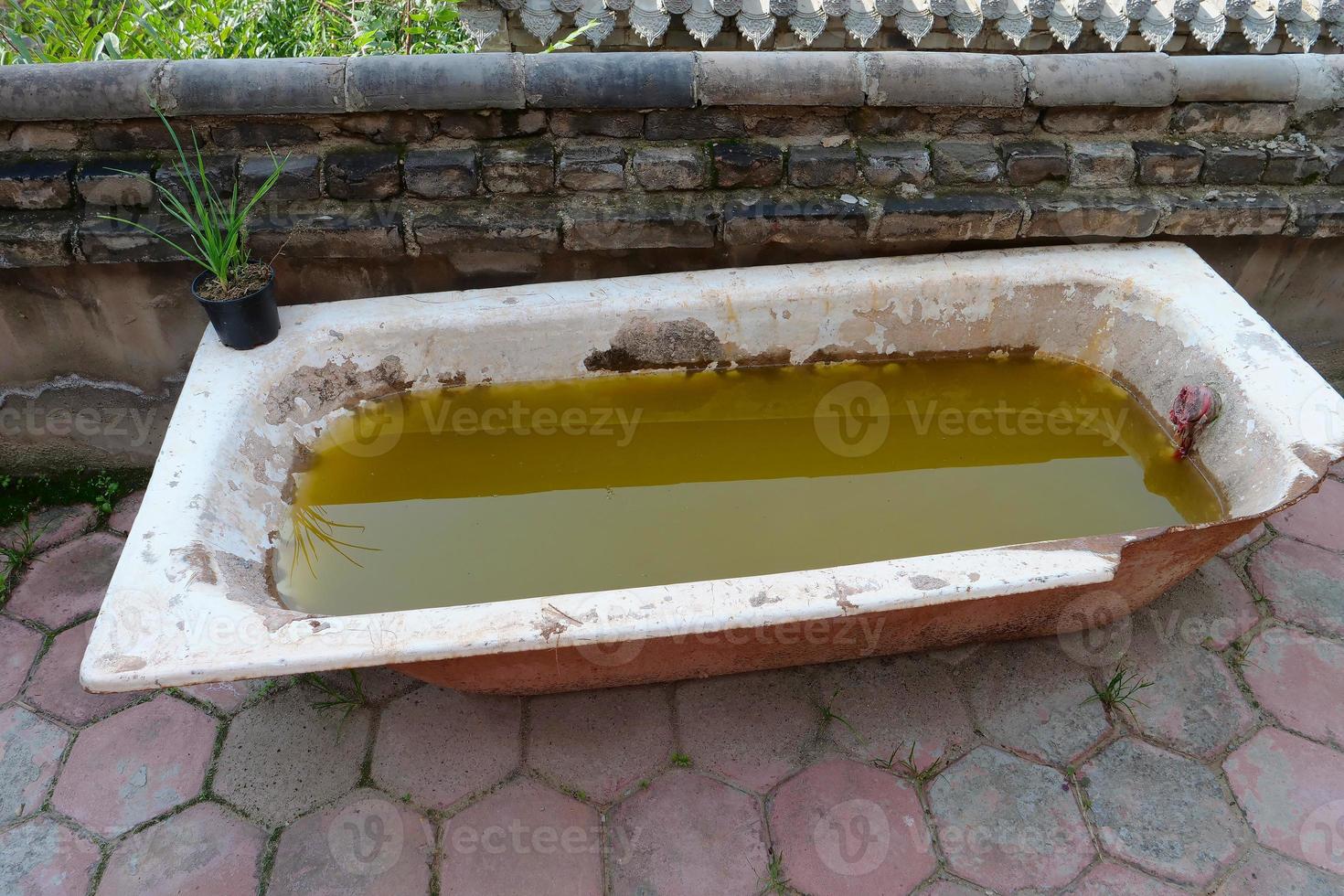 Desert broken bathtub with dirty water inside photo