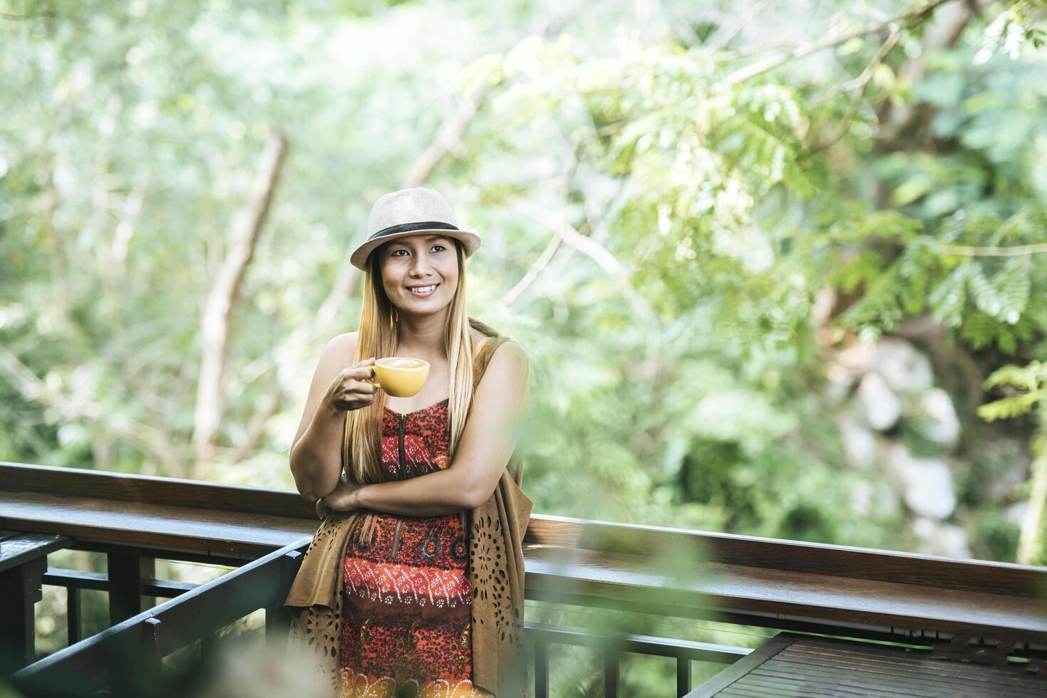 Happy young woman with latte coffee in morning photo