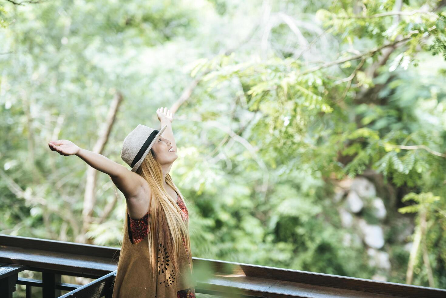 Happy young woman raising her hands in the morning at cafe photo