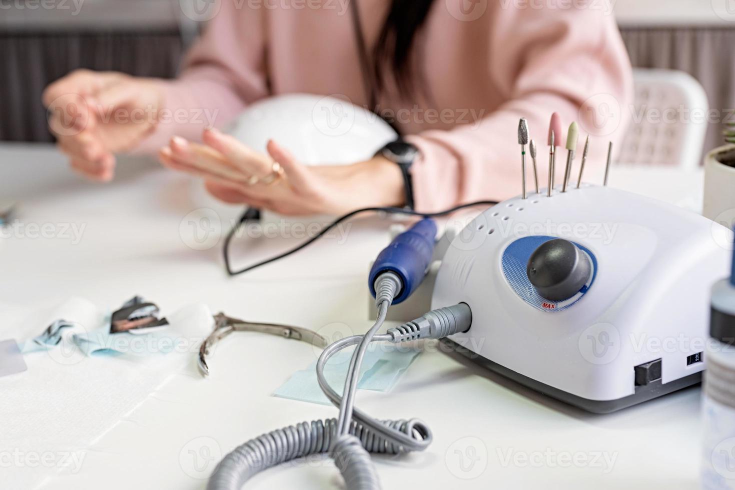 Taladro de uñas o máquina de manicura sobre la mesa en el salón de uñas foto