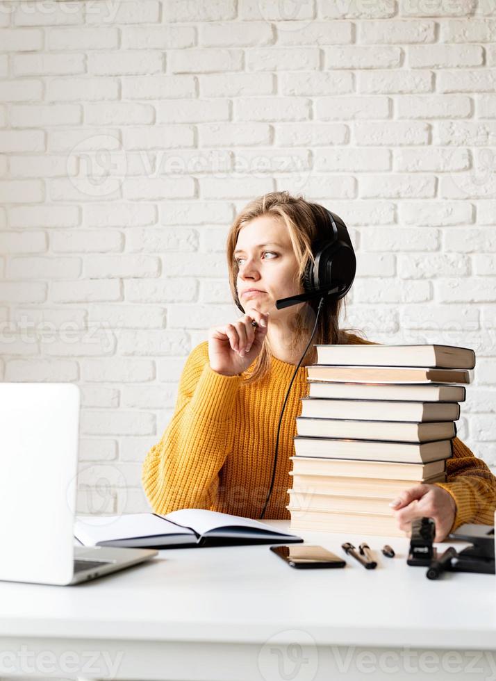 woman studying online using laptop writing in notebook photo